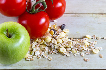 Foods for healthy eating: cottage chesse, apple, cereal on light wood background
