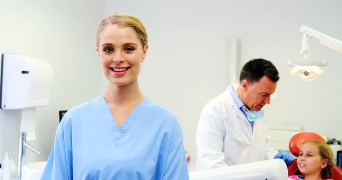Smiling dental assistant standing in dental clinic