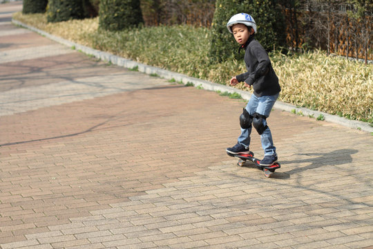 Japanese boy riding on a casterboard (first grade at elementary school)