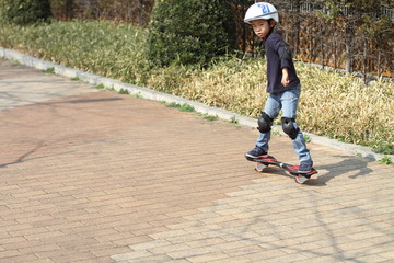 Japanese boy riding on a casterboard (first grade at elementary school)