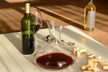 Red wine in decanter, glass and bottle on table