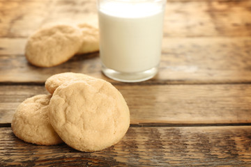 Tasty sugar cookies with glass of milk on table