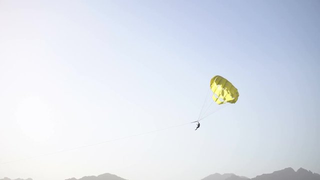 Parasailing over sea in blue sky