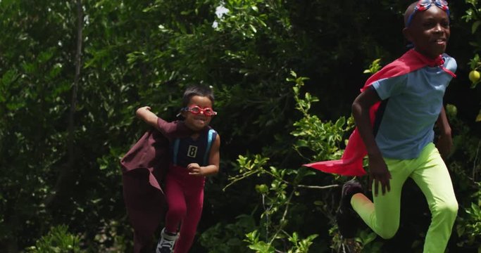 Kids pretend to be superheroes in the park. slow motion.