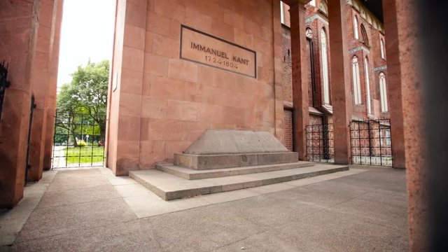 Kaliningrad. Emmanuel Kant Grave. Inscription on Red Wall. Stone on Ground. Old Building. Iron Fence
