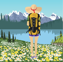 Back view of woman traveler looking at mountain lake in summer