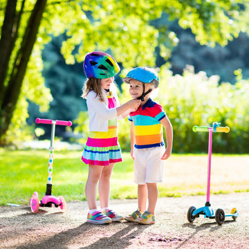 Kids riding scooter in summer park.