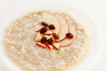 Oatmeal with apple slices and raisins in a bowl. Low fat meals. Breakfast. Vegetarian eating. Healthy Food.