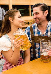Young couple flirting in Oktoberfest beer tent