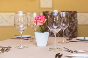 Pink rose in a vase as table decoration. Table setting