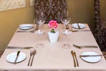 Pink rose in a vase as table decoration. Table setting