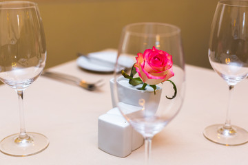 Pink rose in a vase as table decoration. Table setting