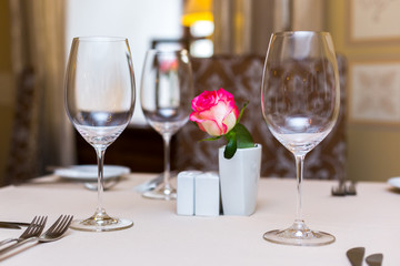 Pink rose in a vase as table decoration. Table setting