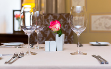 Pink rose in a vase as table decoration. Table setting