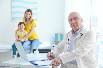 Elderly orthopedist with patients in his office