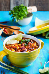 Chili con carne stew served in yellow bowl
