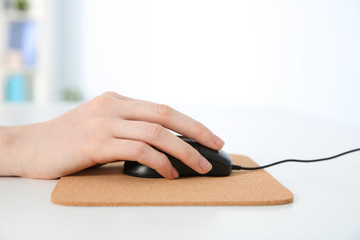 Hand of woman working with computer mouse in office