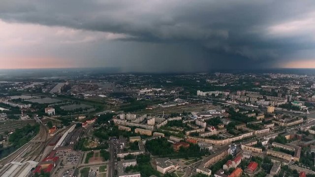 City Before the Rain. Modern Town by River. Buildings on Streets. Cars of Roads. Squares and Green Parks. Heavy Clouds at Middle Raining. Summer