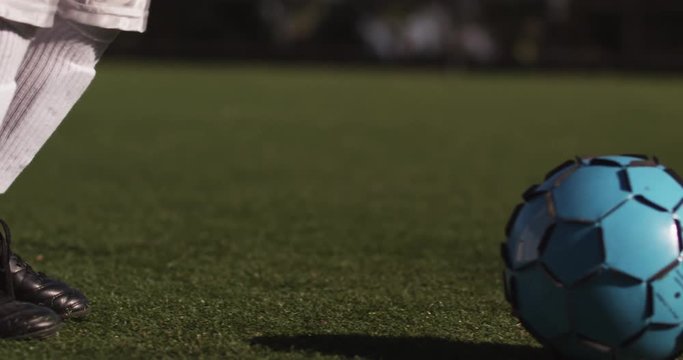 CU on soccer player's cleats kicking a ball down field