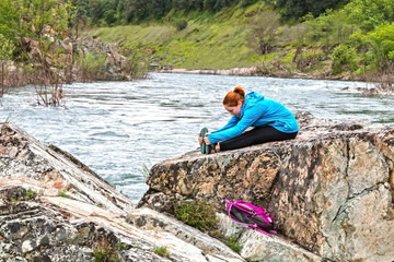 Fototapeta na wymiar Girl Standing on Rocks Near Fast River