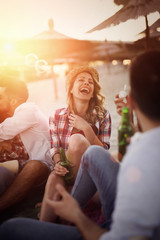 Friends partying and having fun on beach at summer