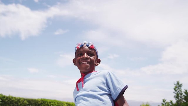 A young child playing dress up fist pumps in slow motion.