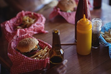 Fast food and beer bottle on table