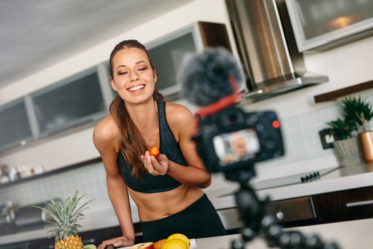 Young woman recording content for her blog in kitchen.