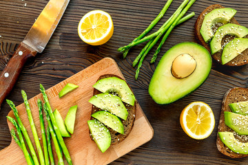 making healthy lunch with bread, lemon, avocado and knife kitchen top view