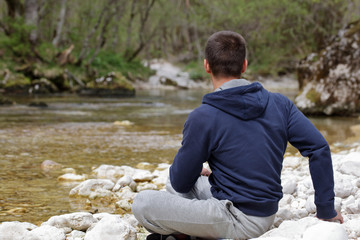 Man relaxing, doing yoga after jogging, workout in beautiful nature landscape. Sport and healhy life style concept