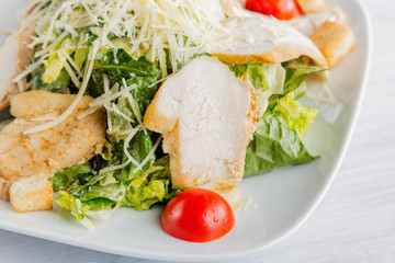 Healthy green organic caesar salad close up on white plate