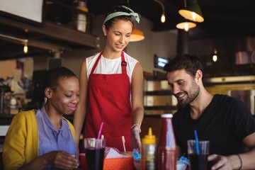 Waitress serving burger and French fries to customer