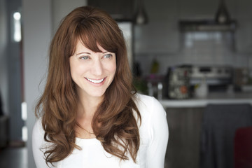 Obraz premium Portrait Of A Mature woman smiling At The Camera. In the kitchen.