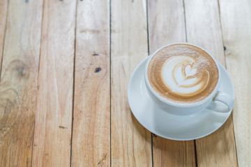Top view of hot coffee latte art on wood table background
