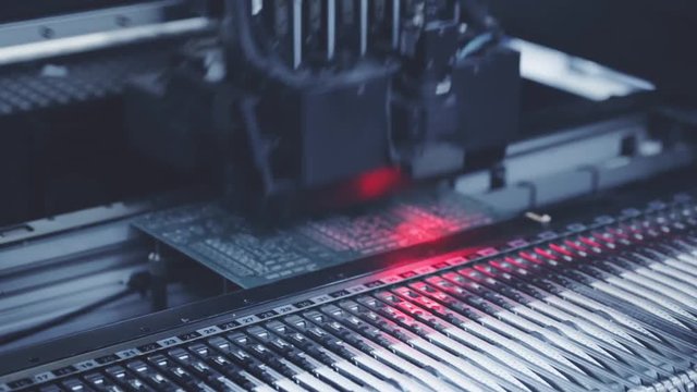 Automated Electronic circuit board production close up. Machine Printe digital board, contract manufacturing. Manufacture electronic microchips. Robotic arm. Red light. High-tech. Full HD. Blue toning