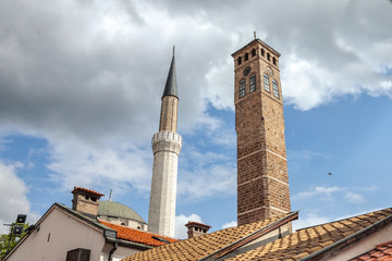 Obraz premium Minaert of the Gazi Husrev begova Mosque next to the clocktower of Sarajevo bazaar, in Bosnia and Herzegovina.
