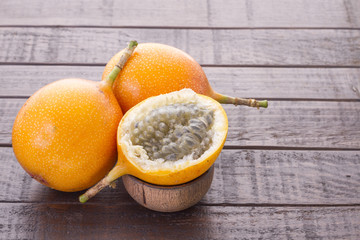 Granadilla, tropical fruits on wooden background (Passiflora ligularis)