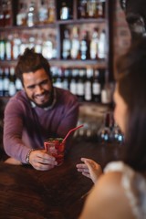 Bartender serving a cocktail drink to customer