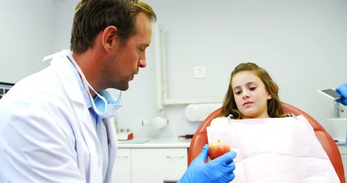 Dentist giving apple to young patient