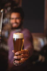  Male bar tender holding glass of beer © wavebreak3