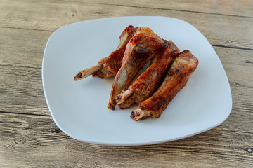 Pork ribs stewed with prunes on a plate.