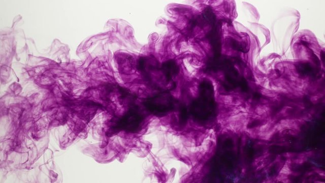Purple dye expands into a cloud in clear water over a white BG. Slow motion.