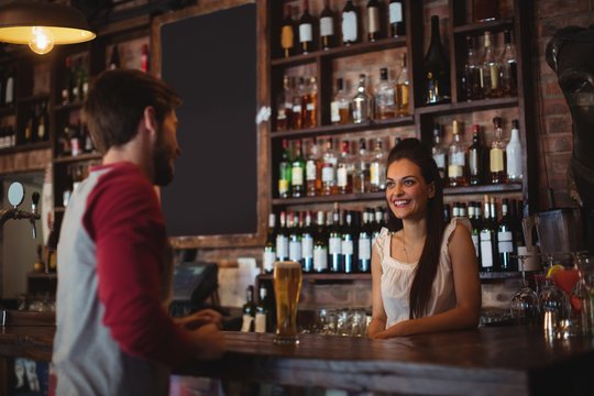 Female bar tender interacting with customer