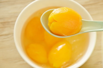Marian plum tropical fruit in syrup with ice cold dessert on spoon