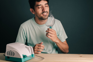 Portrait of man breathing relieved after using inhaler / nebulizer