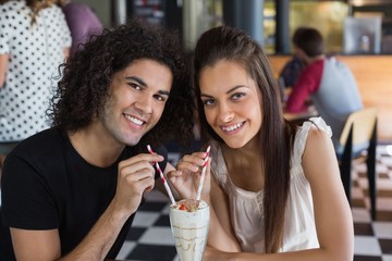 Portrait of smiling couple having drink in restaurant