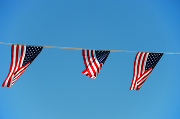 USA national flags hanging under sunny sky in holiday