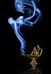Magic Aladdin lamp with smoke on a dark background