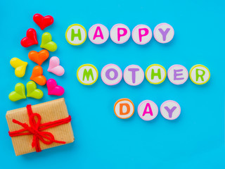 mother's day concept.  HAPPY MOTHER DAY alphabet with colorful heart and gift on blue background