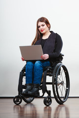 Disabled woman with laptop on wheelchair.